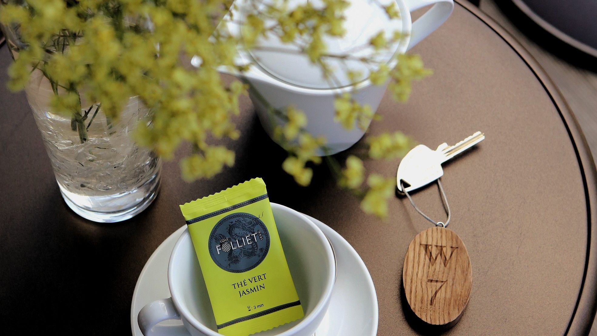 tasse de thé et clé de chambre sur une table basse