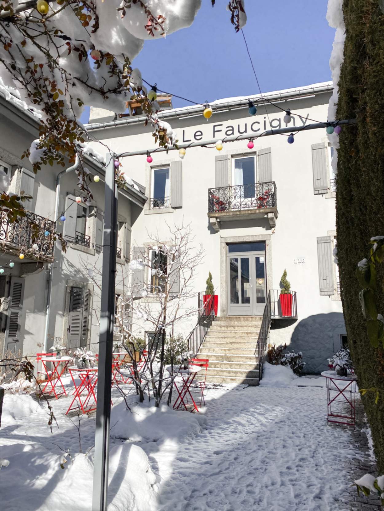 Entrée de l'hôtel le Faucigny ensoleillée et sous la neige