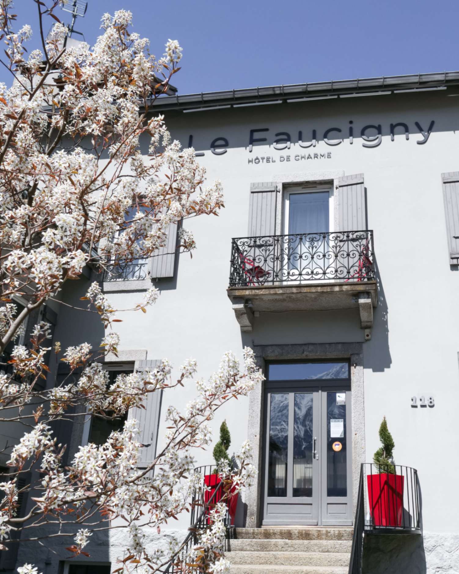 Entrée Faucigny Hôtel fleurie au printemps
