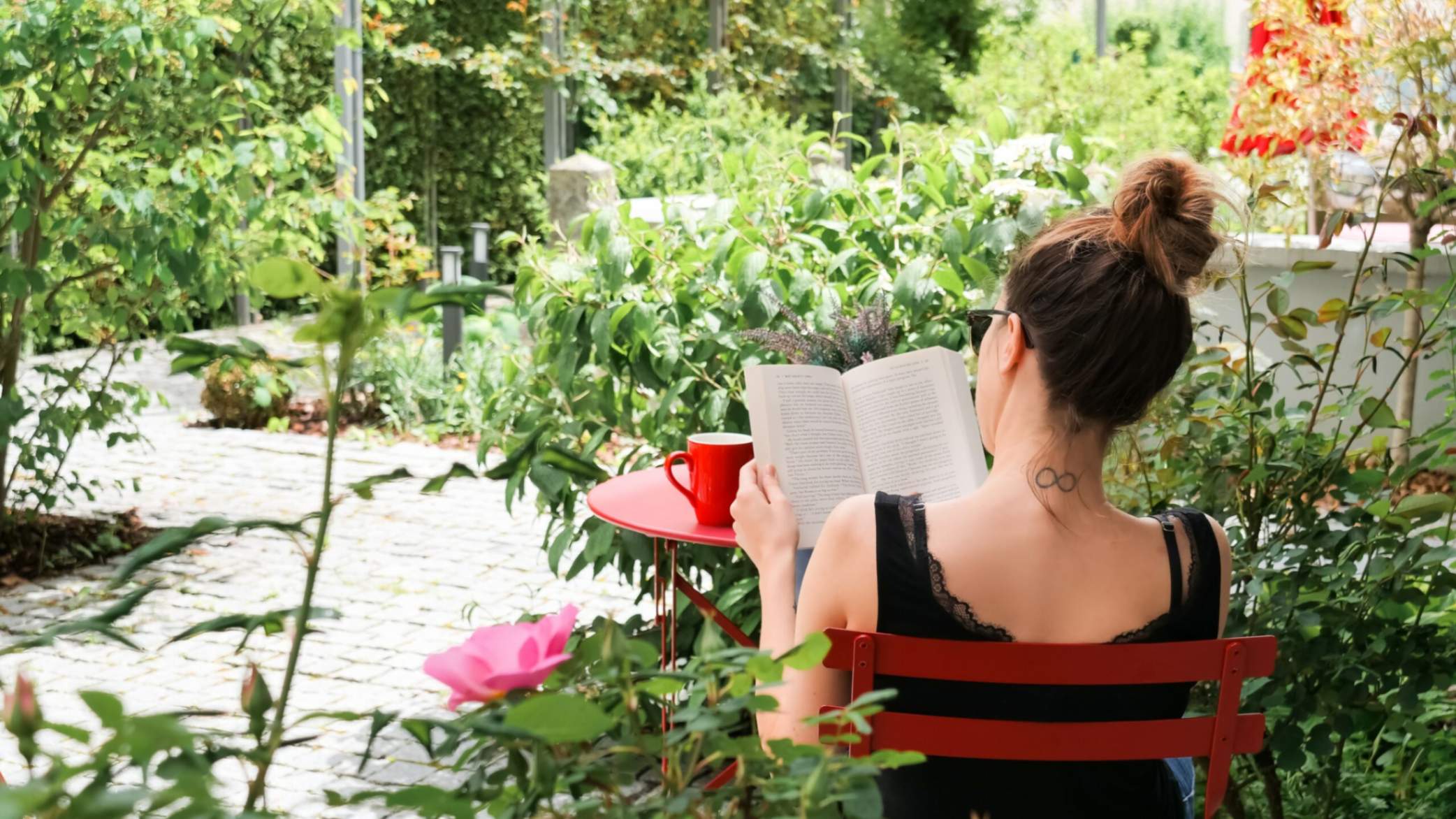 Femme qui lit sur la terrasse du Faucigny à l'ombre des arbres