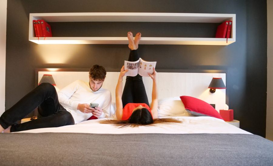 couple resting on a bed in a family room